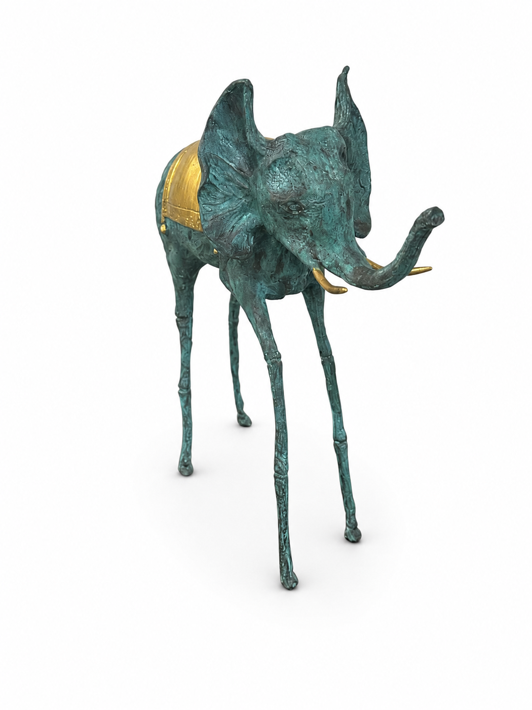 green bronze elephant sculpture with a gold saddle on a white background. Diagonal view. 