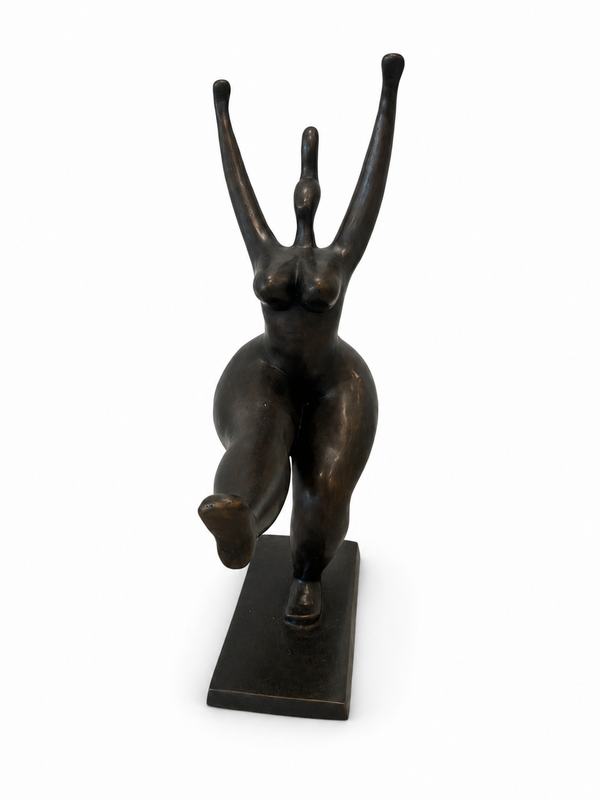 Bronze sculpture of abstracted standing lady with one leg up and both hands up on a white background