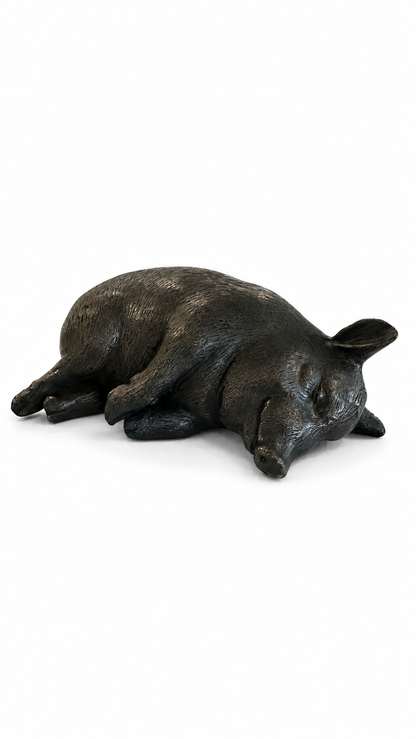 Bronze sculpture of a sleeping pig on a white background. side view