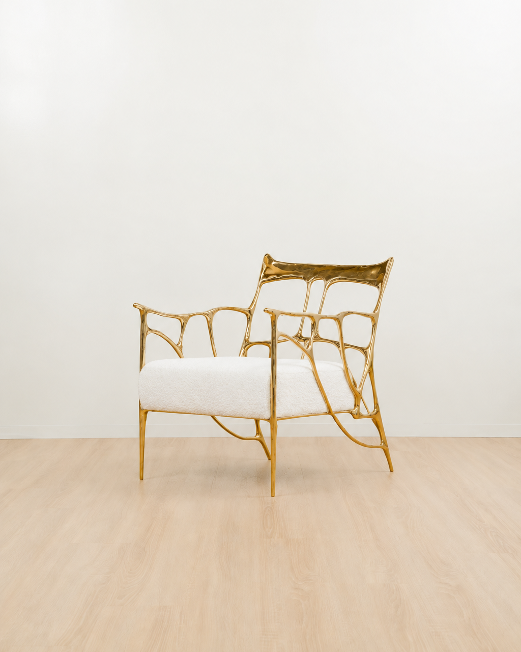gold, polished brass armchair with white cushion on a light wooden floor. side view