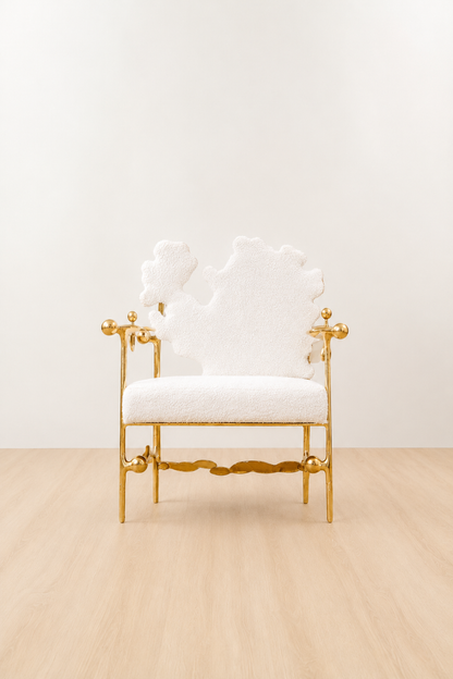 gold brass polished chair with white cushion on a beige floor and light beige wall. straight view.
