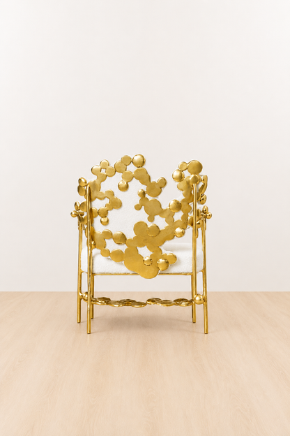 gold brass polished chair with intricate back design on a beige background