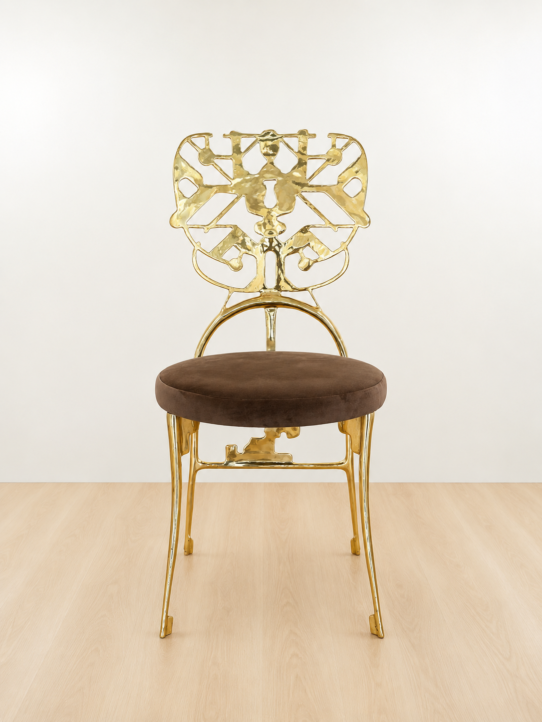 Gold chair with intricate design with brown velvet seat on a white background. Luxury handmade furniture. front angle