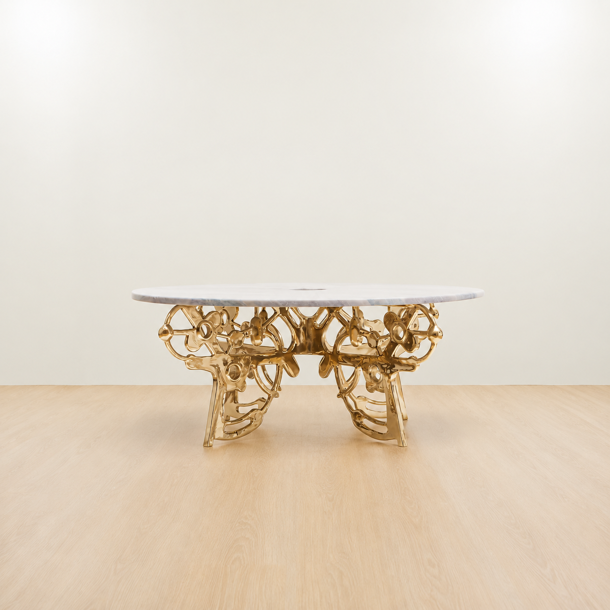 Gold brass coffee table with an organic sculptural base and grey marble top