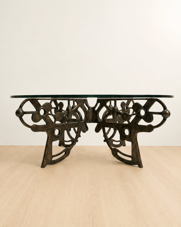 brass coffee table with intricate design with a glass table top