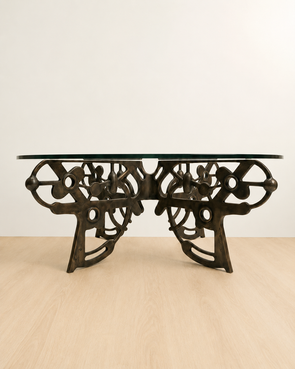 brass coffee table with intricate design with a glass table top