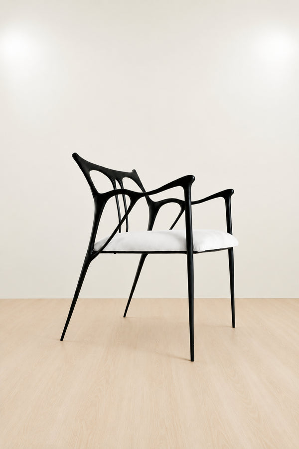 Modern black brass chair with white seat on a beige floor and wall