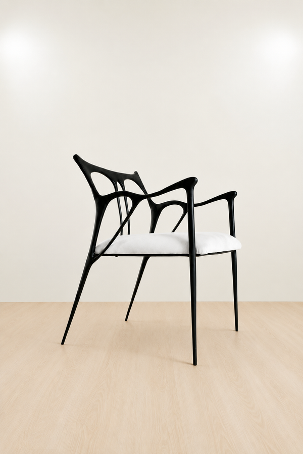 Modern black brass chair with white seat on a beige floor and wall