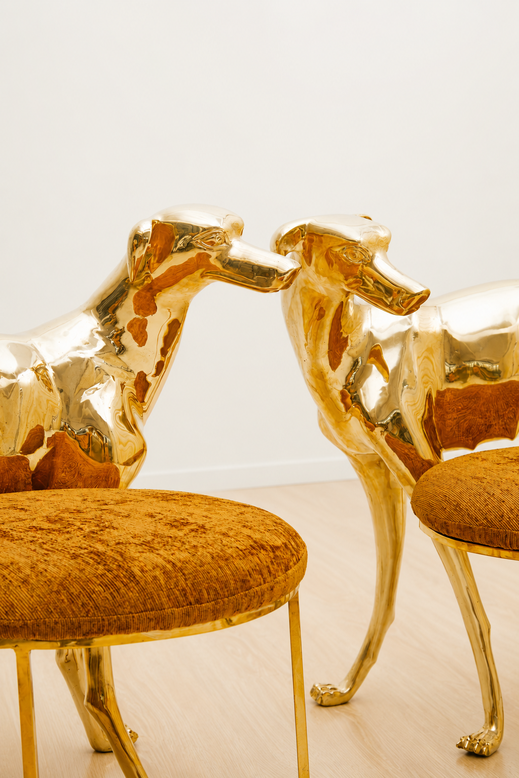 Gold brass dog-shaped chairs with brown cushions on a light background