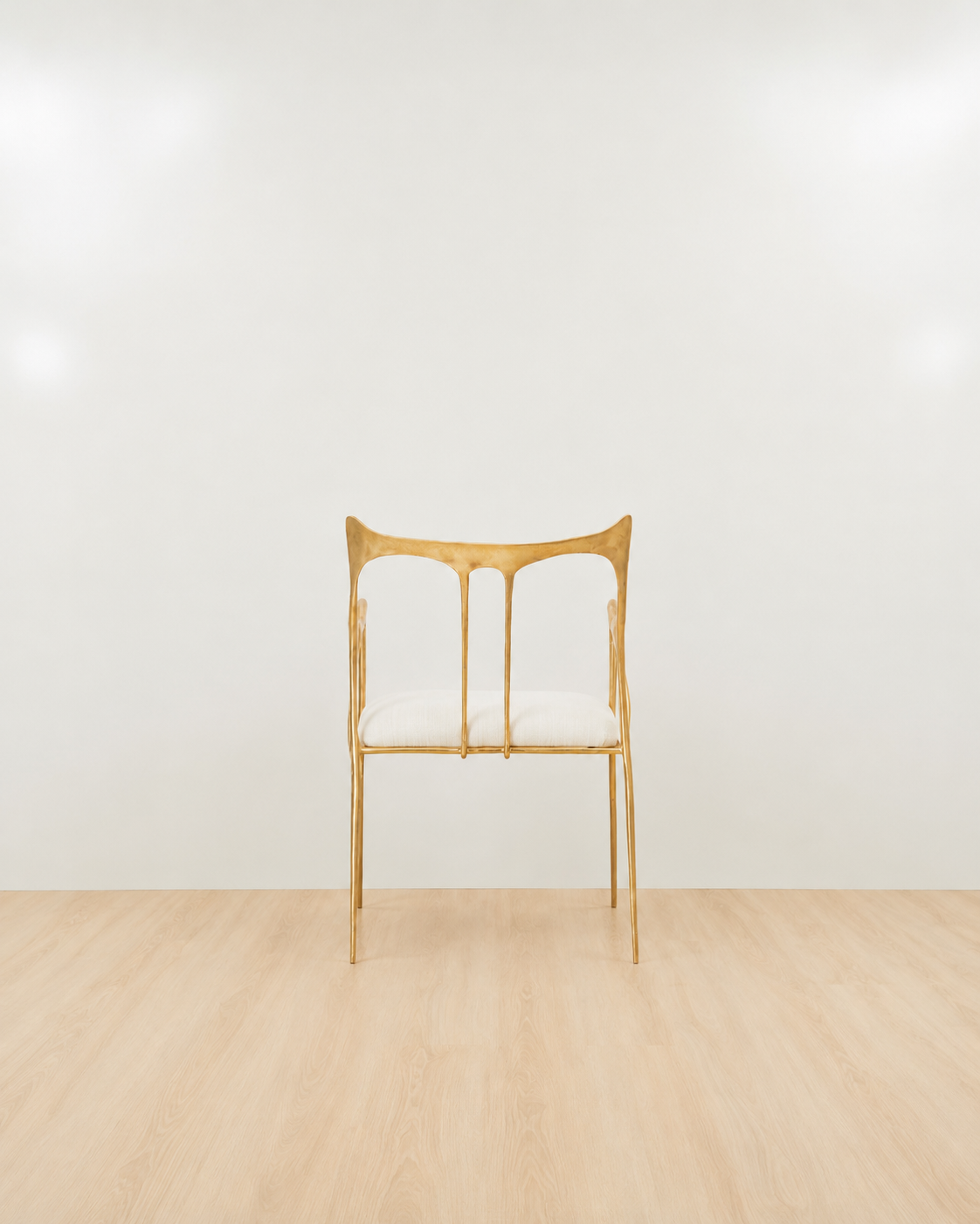 back of a Luxury handmade brass chair with gold finishing and white cushion on a white background. 