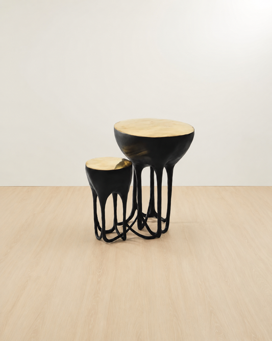 a black side table with gold top on a 