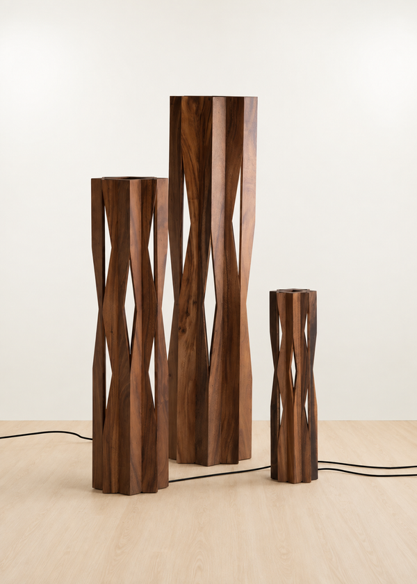 Three modern wooden sculptural lamps in varying heights, featuring twisted geometric slat designs in dark walnut wood, displayed on a light wood floor against a neutral off-white background.
