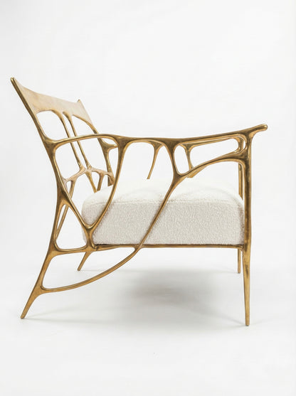 Modern chair with a unique, organic brass frame design on a white background