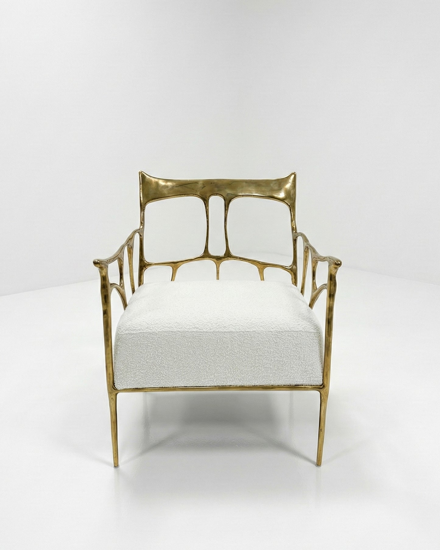 Gold brass armchair with white cushion on a white background