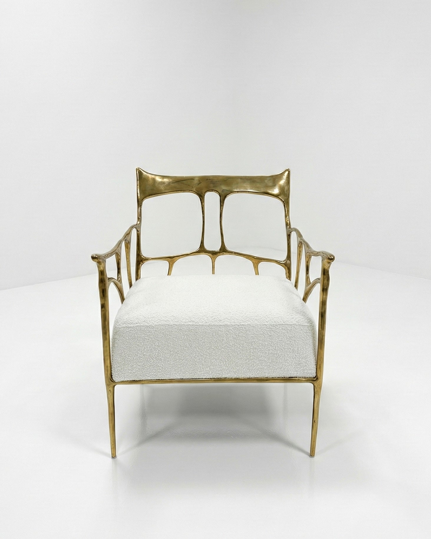 Gold brass armchair with white cushion on a white background