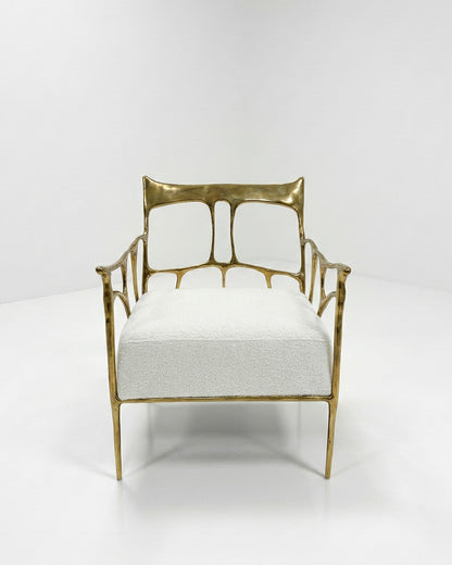 Gold brass armchair with white cushion on a white background