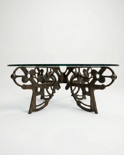Decorative bronze coffee table with intricate design on a white background