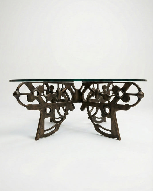 Decorative bronze coffee table with intricate design on a white background