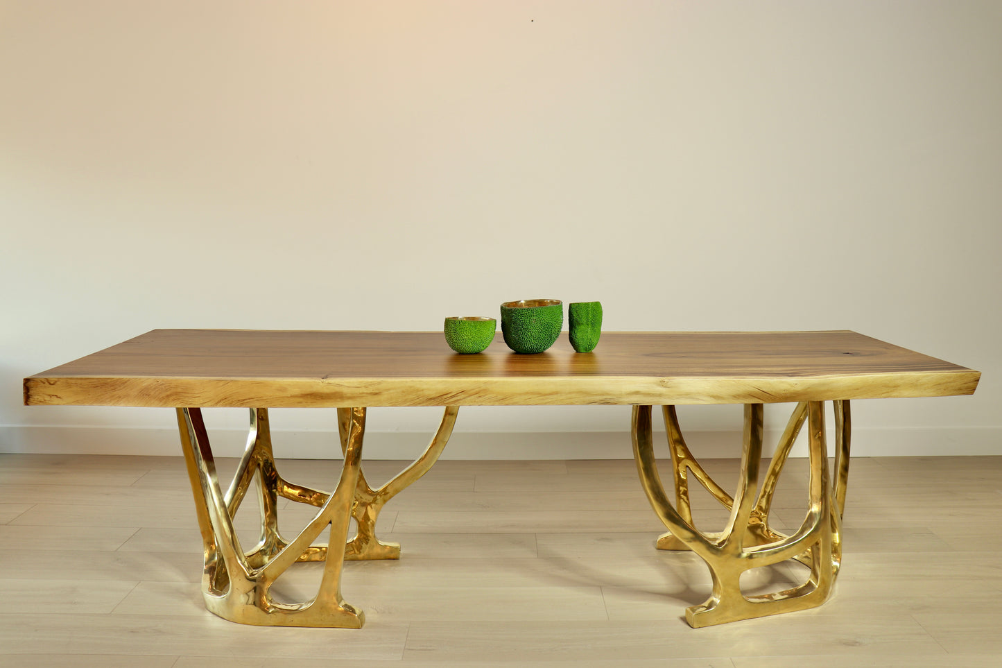 Wooden table top with gold metal legs on a plain background