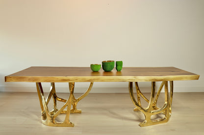 Wooden table top with gold metal legs on a plain background