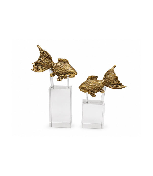 Two gold fish sculptures on clear stands against a white background