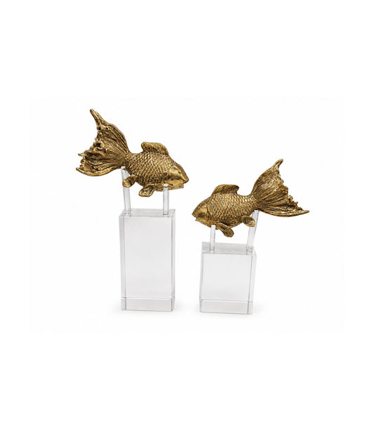 Two gold fish sculptures on clear stands against a white background