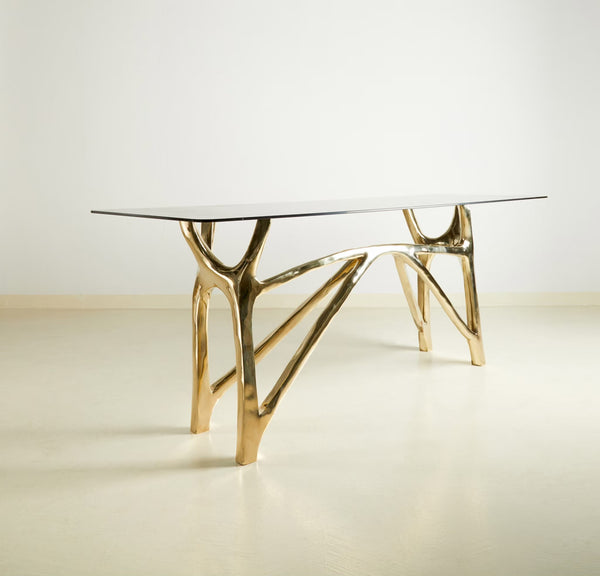 Custom console table with gold finish and glass top.