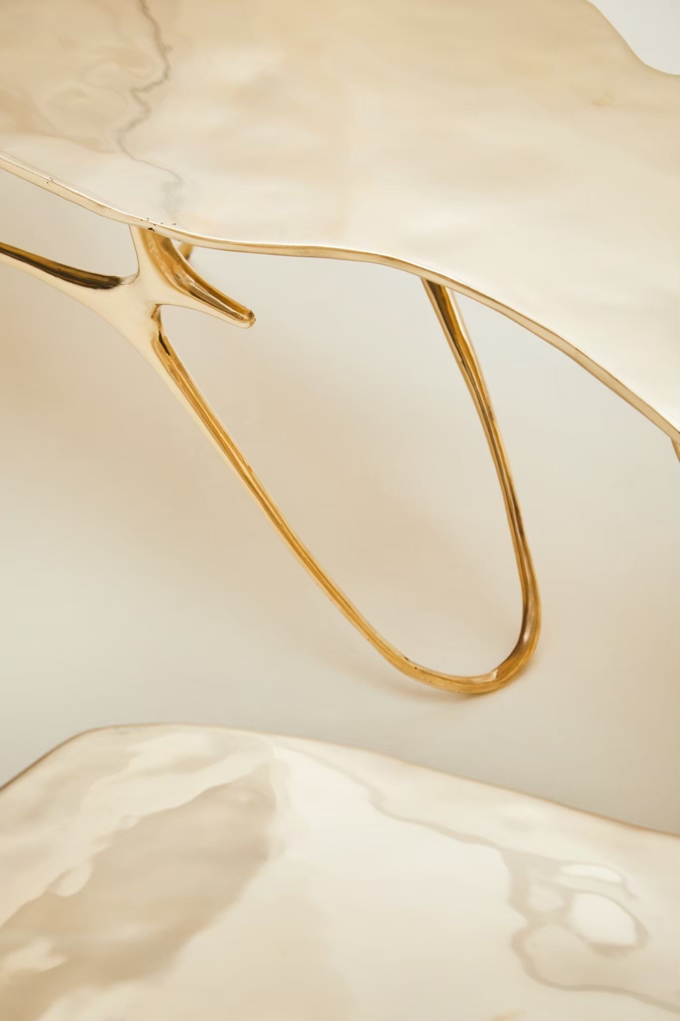 zoom in detail of leg of gold brass bench. 