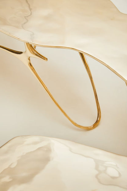 zoom in detail of leg of gold brass bench. 