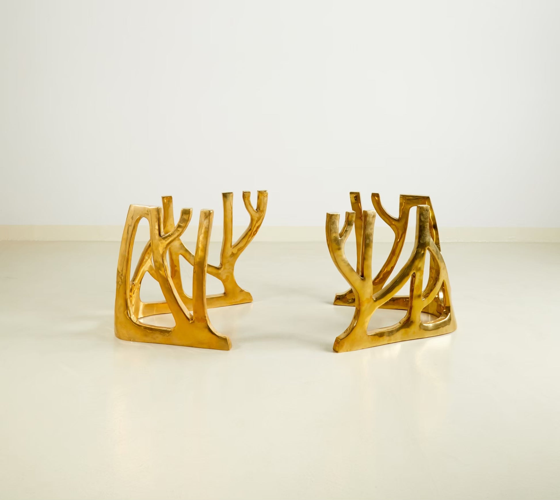 Modern gold metal table base with an organic, branching coral-like silhouette, displayed on a clean white surface against a white background.