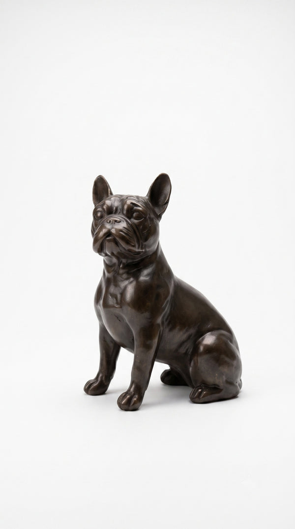 A dark bronze-finished sculpture of a sitting French Bulldog, photographed against a seamless white studio background.
