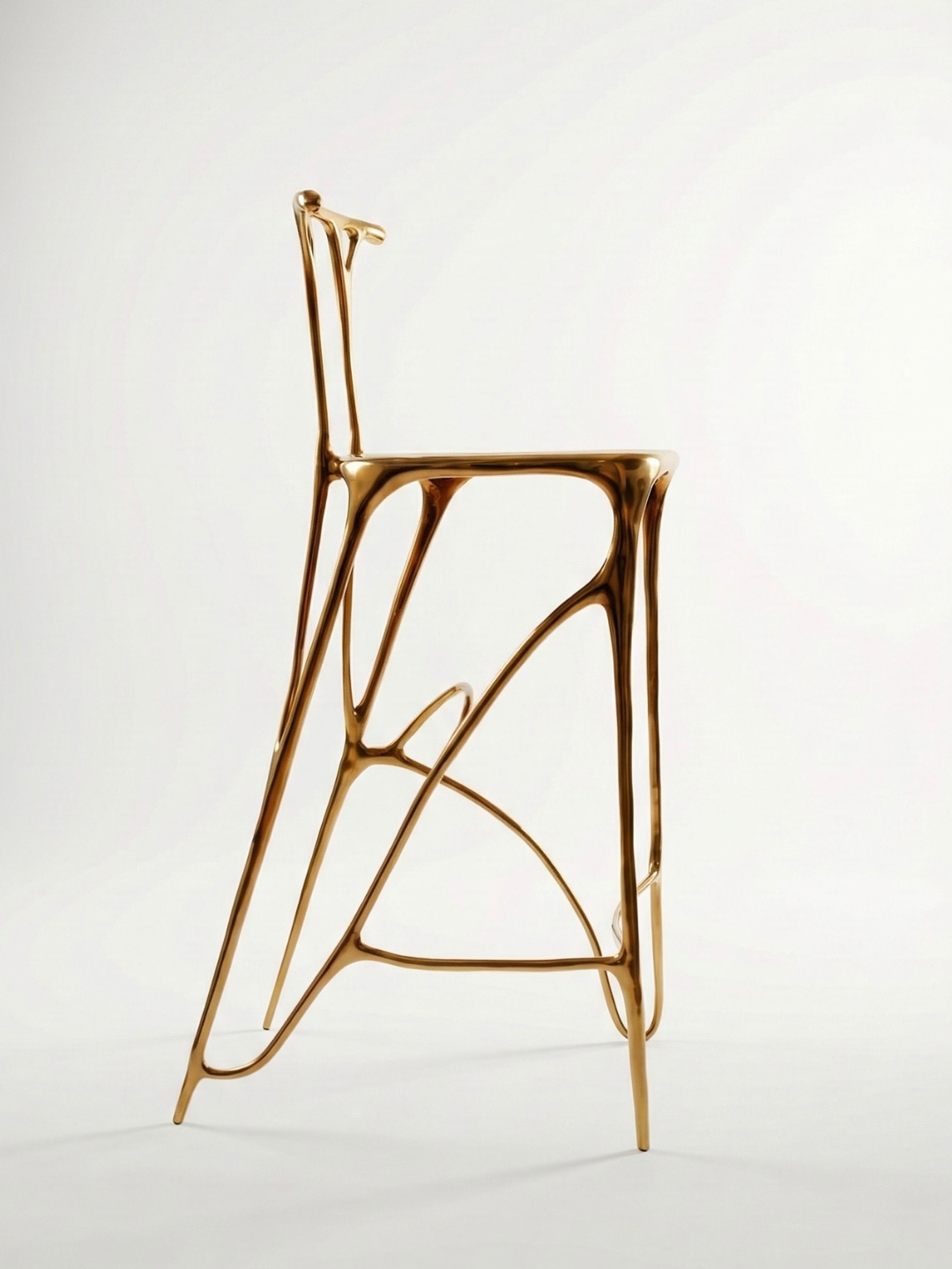 Sumi brass stool side profile. Gold finish and sculptural brass frame. Click to view product.