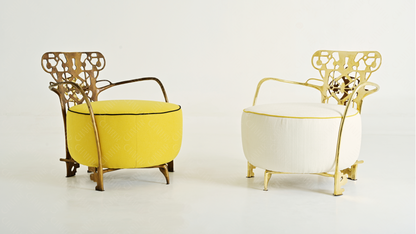 Two ornate chairs with gold frames and yellow and white cushions on a white background. Luxury handmade furniture. 