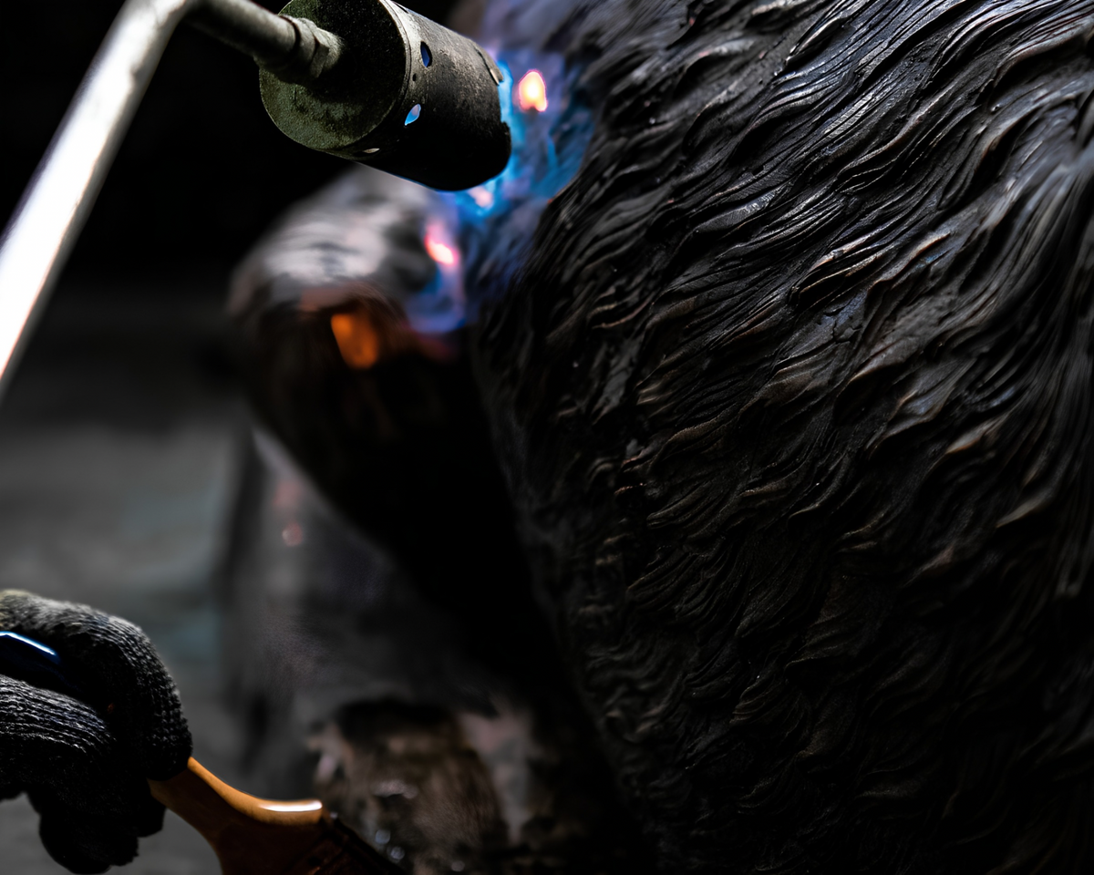 Bronze statue being heat treated to a matte black color.
