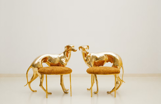 Two gold brass luxury handmade furniture dog-shaped chairs with cushioned seats, ideal for modern luxury decor, on a white background.