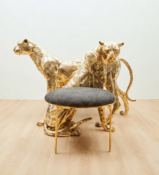 Gold brass luxury handmade furniture panther chair with gray cushion, perfect for modern luxury decor, on a wooden surface.