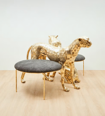 Gold brass luxury handmade furniture panther-shaped chair with gray cushion, ideal for modern luxury decor, on a beige floor.