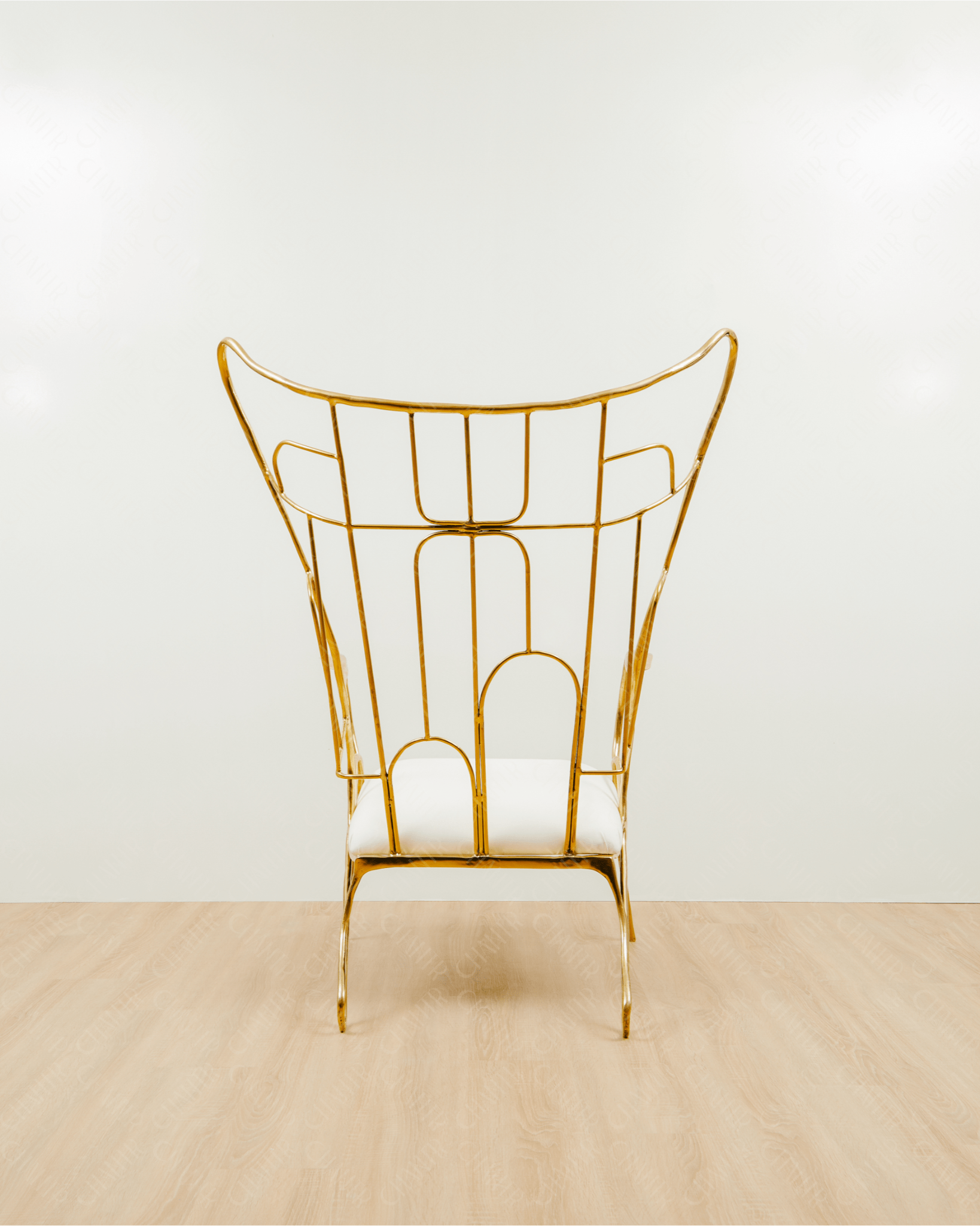 Gold brass luxury handmade furniture chair with white cushion on a light wooden floor, paired with a gold brass side table topped with a white vase, perfect for modern luxury decor. back