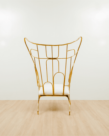 Gold brass luxury handmade furniture chair with white cushion on a light wooden floor, paired with a gold brass side table topped with a white vase, perfect for modern luxury decor. back