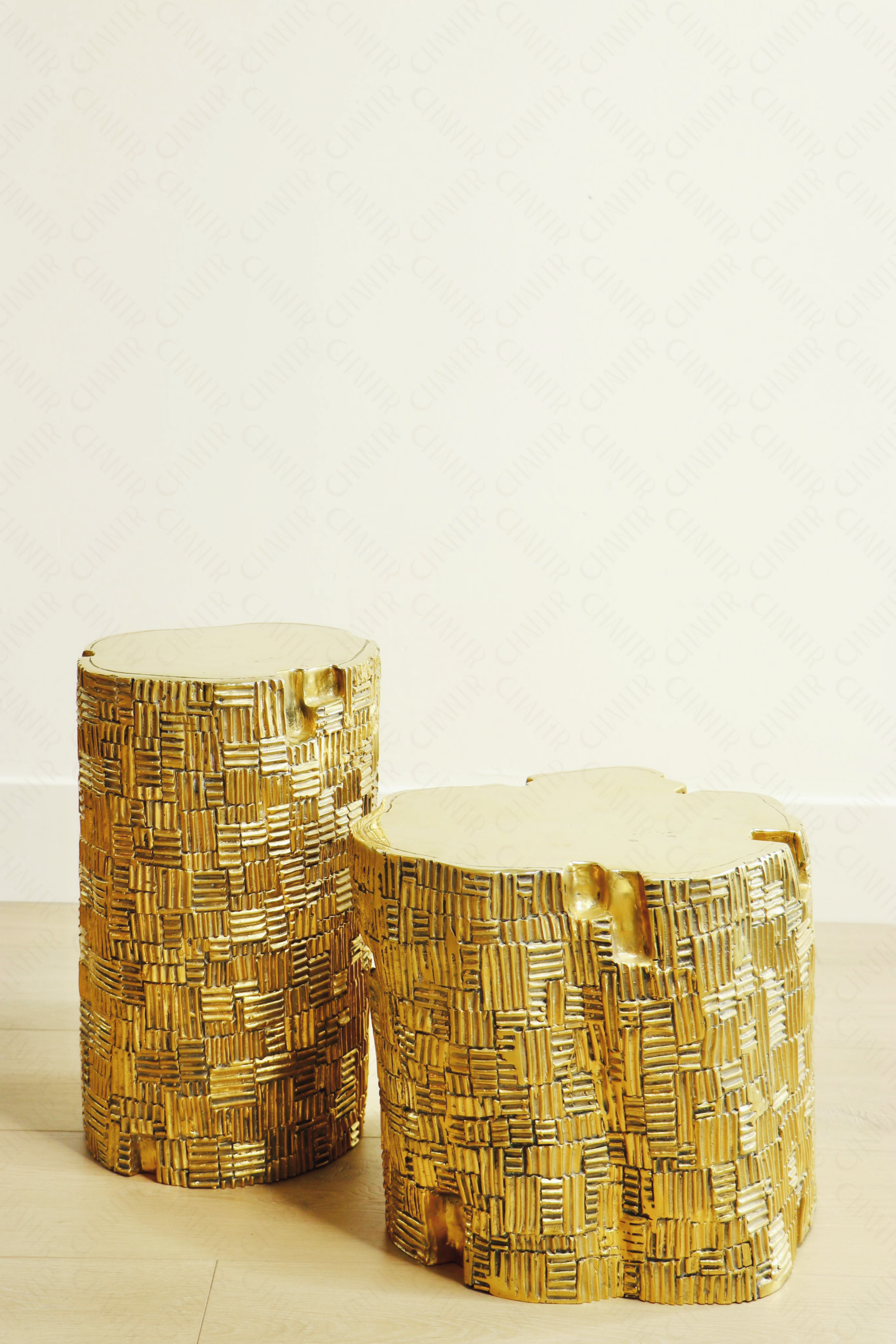 Two gold decorative luxury handmade furniture stools, one tall, one short, with woven patterns, ideal for modern luxury decor, on a light background.