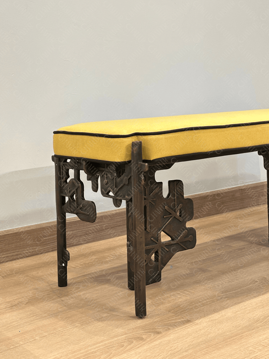 Brass luxury handmade furniture bench with yellow cushioned seat, ideal for modern luxury decor, against a white wall. zoomed in