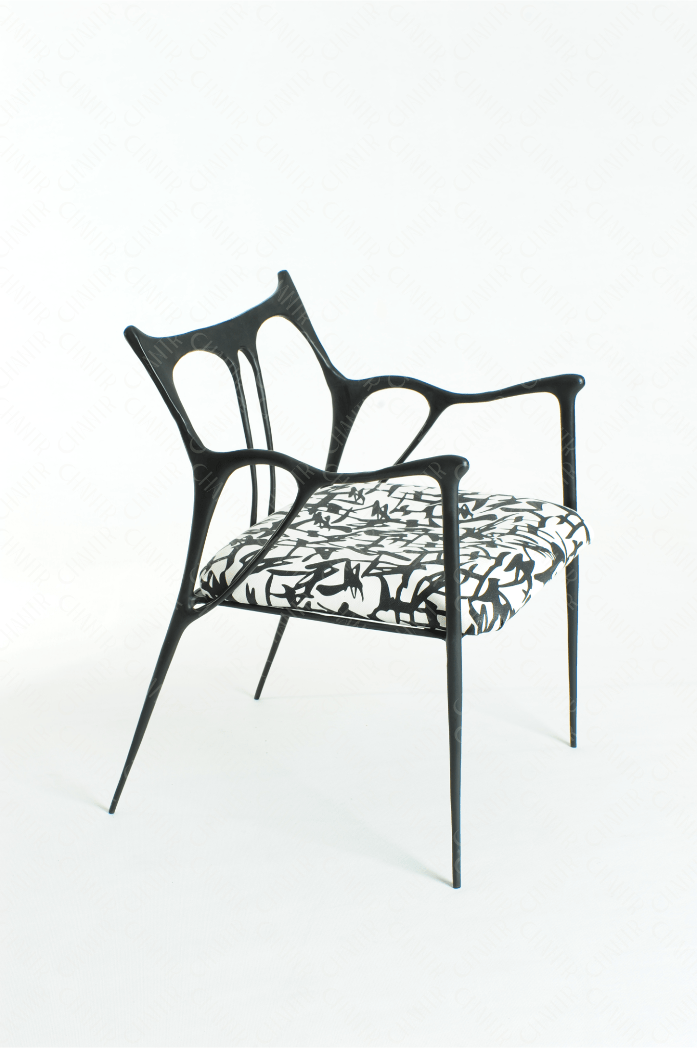 Black brass luxury handmade furniture chair with patterned cushion, ideal for modern luxury decor, on a wooden floor.