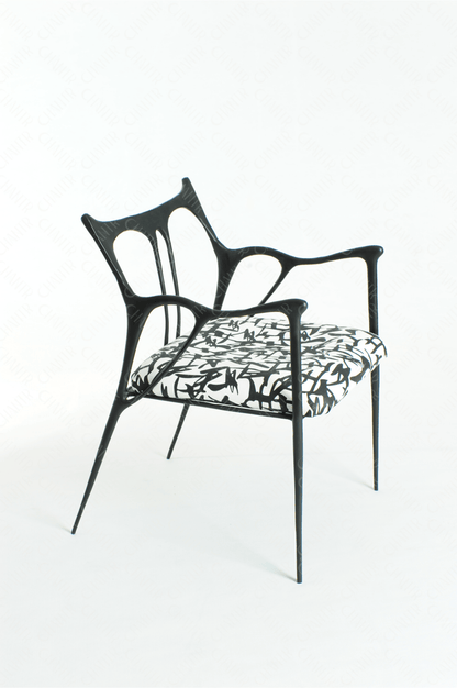 Black brass luxury handmade furniture chair with patterned cushion, ideal for modern luxury decor, on a wooden floor.