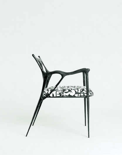 Black brass luxury handmade furniture chair with patterned cushion, ideal for modern luxury decor, on a wooden floor.