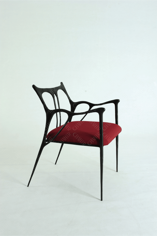 Black brass luxury handmade furniture chair with red cushion, ideal for modern luxury decor, on a wooden floor.