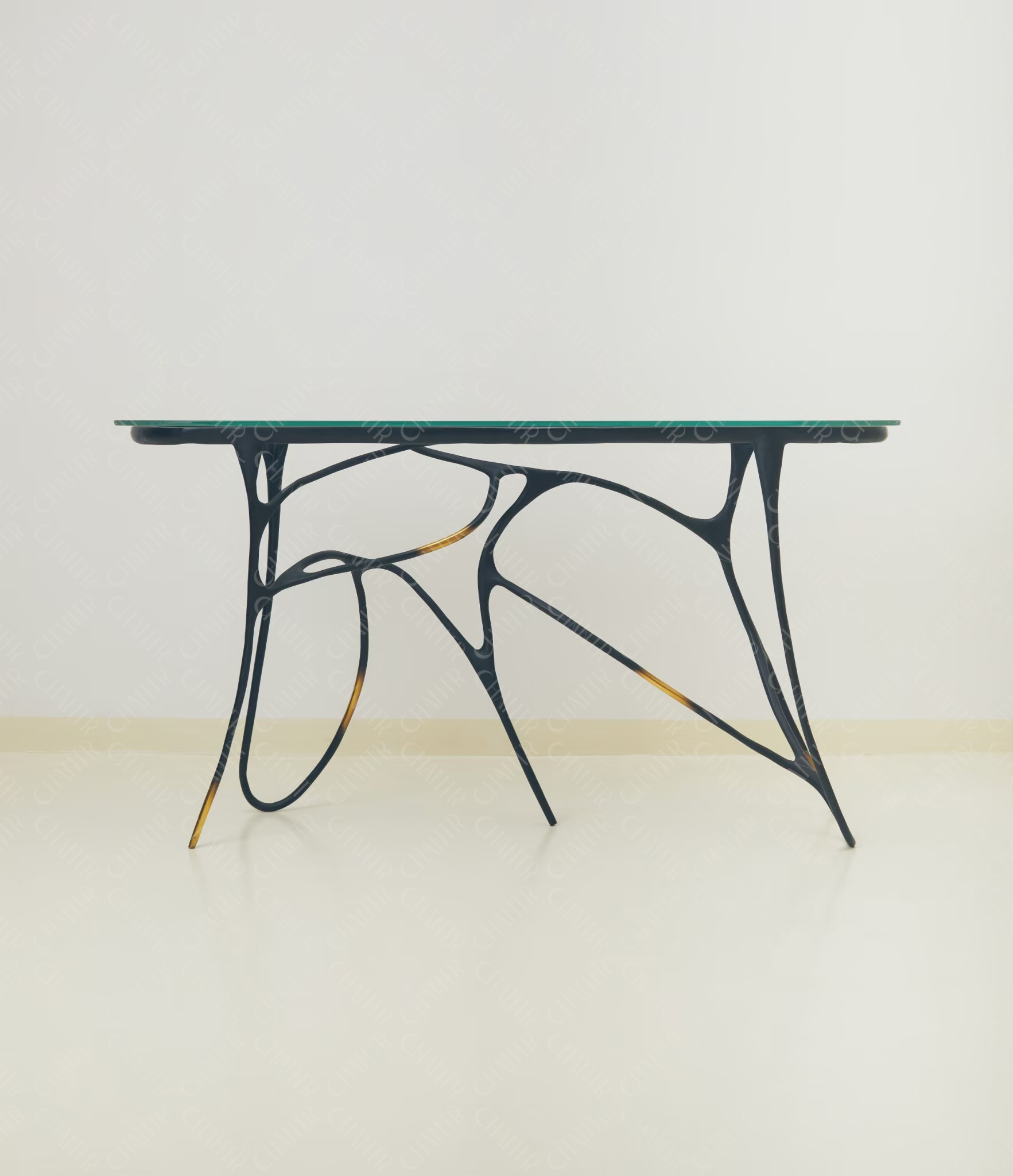 Black brass luxury handmade furniture table with organic design and glass top, perfect for modern luxury decor, on a light wooden floor with white wall background.
