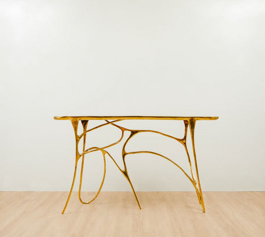 Gold brass luxury handmade furniture table with organic design, perfect for modern luxury decor, on a light wooden floor with white wall background.