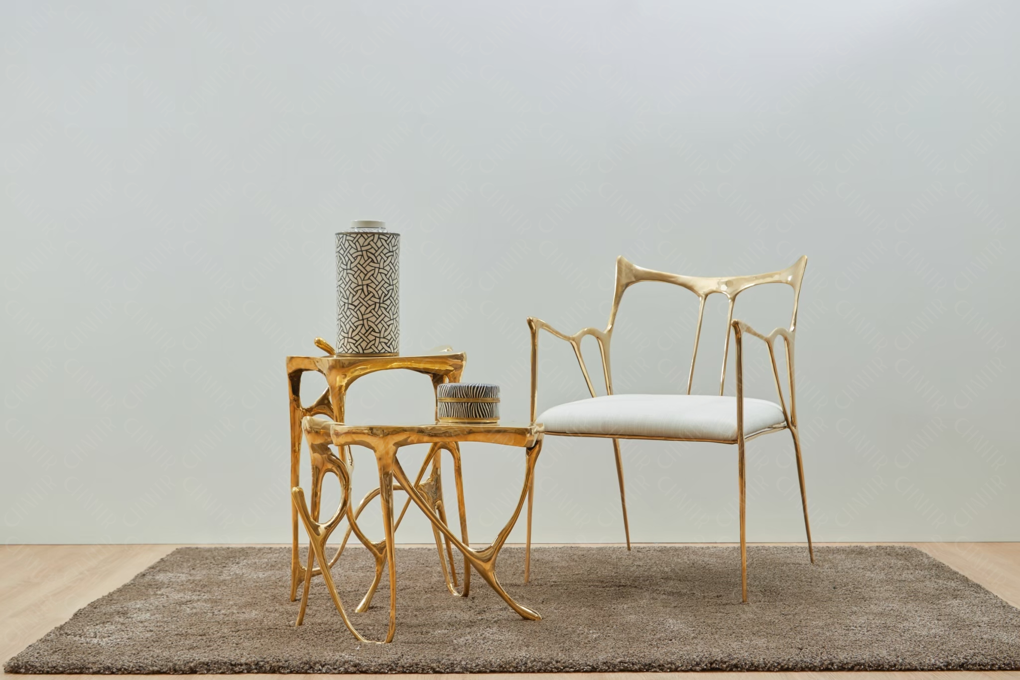 Gold chair and side table on a gray rug with a plain background. Luxury handmade furniture