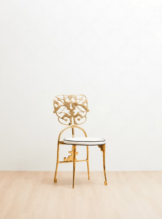 Gold chair with intricate design on a white background. Luxury handmade furniture.