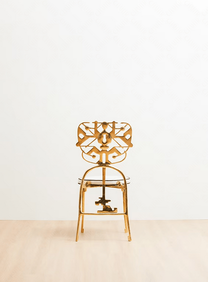 Gold chair with intricate design on a white background. Luxury handmade furniture. Back angle